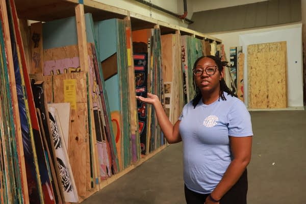 woman shows plywood art in storage
