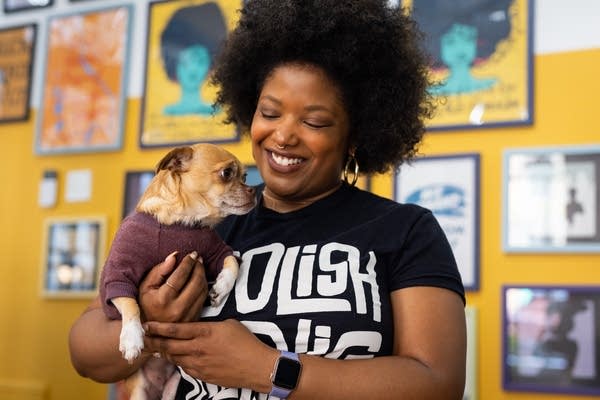 A woman holds a small dog