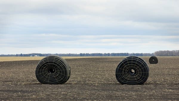 Large rolls of drain tile sat in a field.