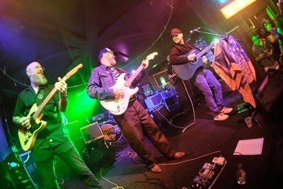 Three musicians performing onstage