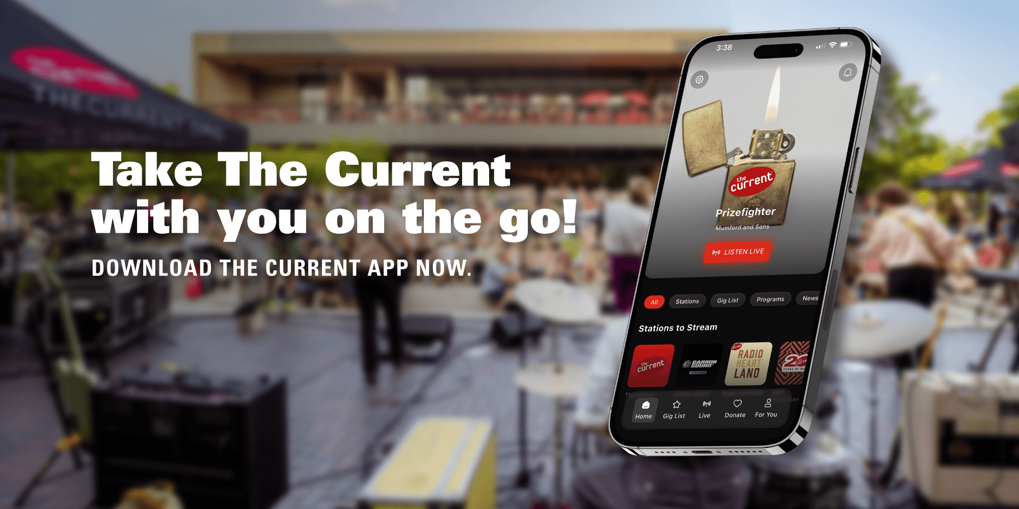 The Current's app displays on a mobile phone screen. A band is set up on the stage of an outdoor venue in the background.