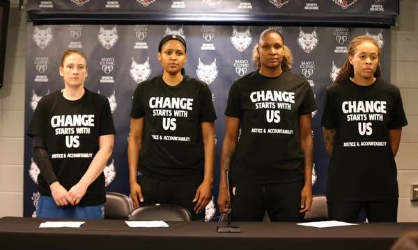 Four women stand together