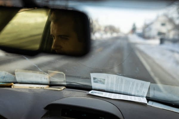 A person is reflected in the rear view mirror