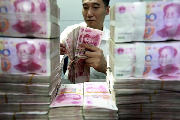 A Chinese clerk counts banknotes. (Photo by Jie Zhao/Corbis via Getty Images)