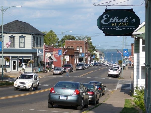 A view down a sloping commercial street towards a body of water