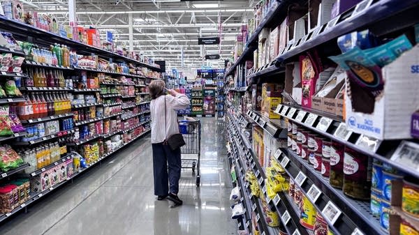 A customer walks down a supermarket aisle