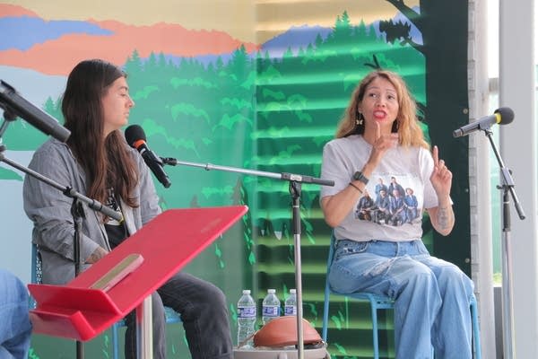 Two people talk on a stage