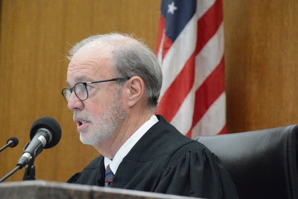 A judge speaks into a microphone