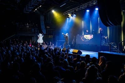 A hip-hop group performing onstage in a music venue