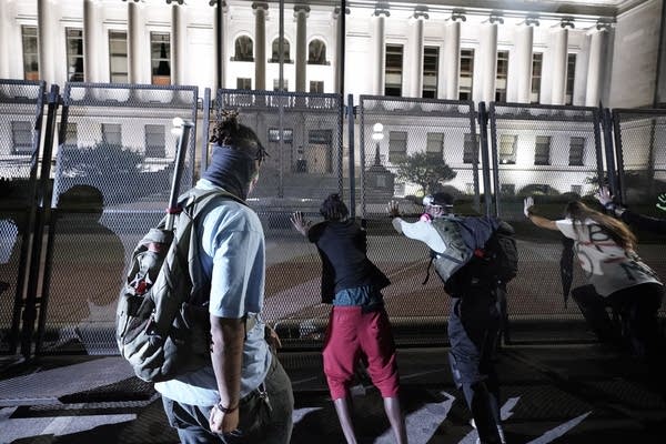 People try to push over protective fencing.