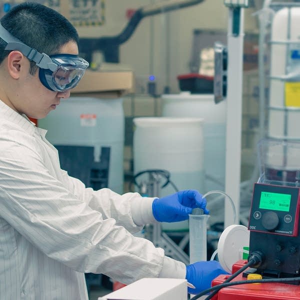 A person wears lab equipment in a lab