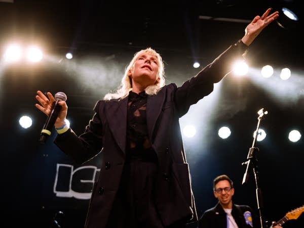 Amelia Meath holds up her arms on stage.