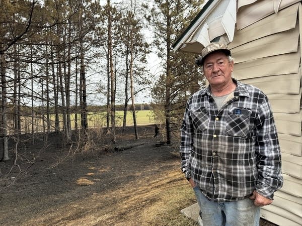 Larry Roberts stands next to his house in Crosby