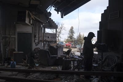 An employee helps to clean up a damaged building 