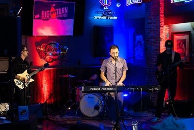 Three men performing on stage
