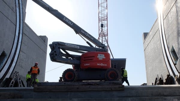 a construction crane next to large concrete walls