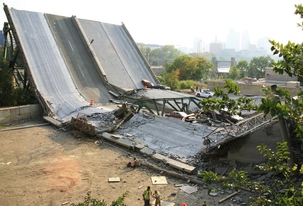 People stand alongside the Interstate 35W bridge after it collapsed.