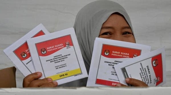 An Indonesian woman shows her ballots for the country's general election at a polling station in Jakarta on April 17, 2019. - Indonesia's Joko Widodo was on track to be re-elected as president of the world's third-biggest democracy on April 17 with pollsters giving him a wide lead over rival Prabowo Subianto, an ex-general.