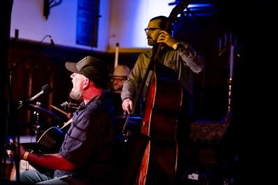Two musicians perform together onstage