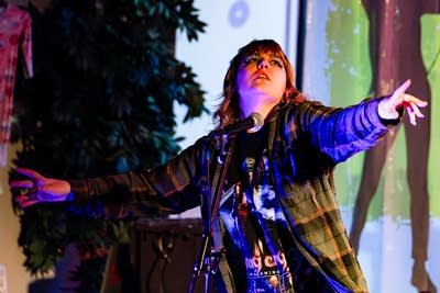 A musician sings onstage in a nontraditional music venue