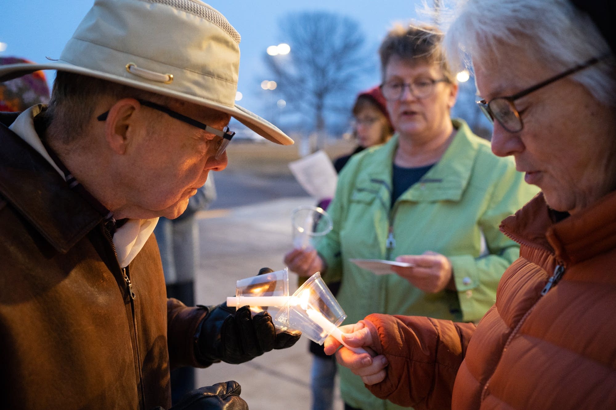 Lawrence Cook, left, lights his candle with Gigi Nauer's.