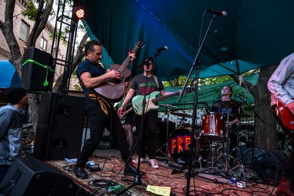 A rock band performing on an outdoor stage