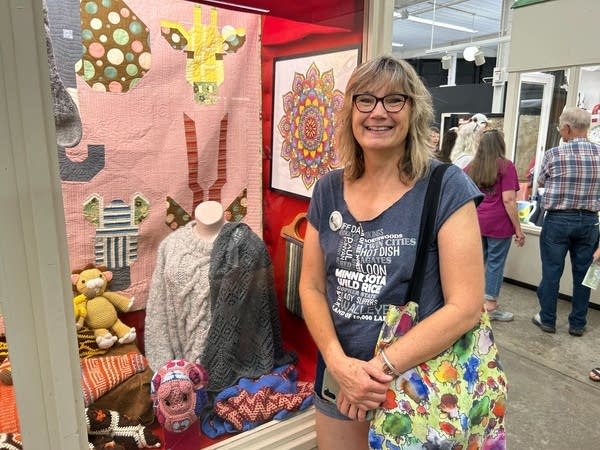 woman standing next to knitted sweater at state fair