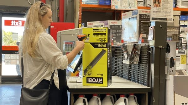 A customer scans items in a self-checkout lane at a Home Depot store.