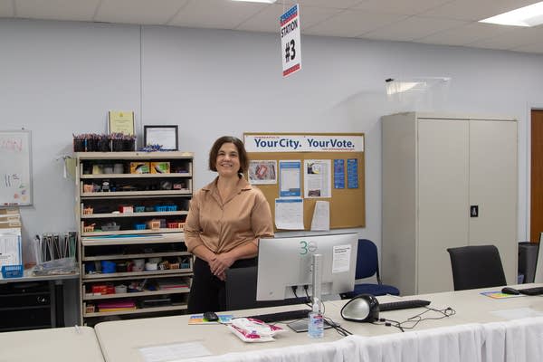 A woman stands behind a table at a Minneapolis election office.