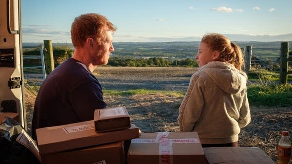 A man and girl sit in a vehicle