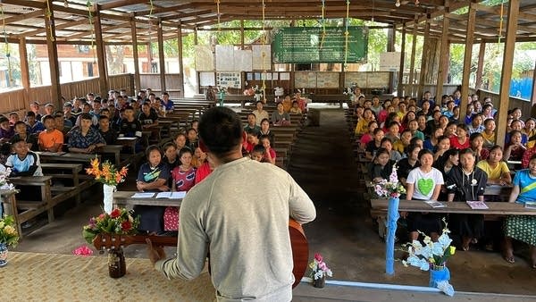 A man sings to a group of students.