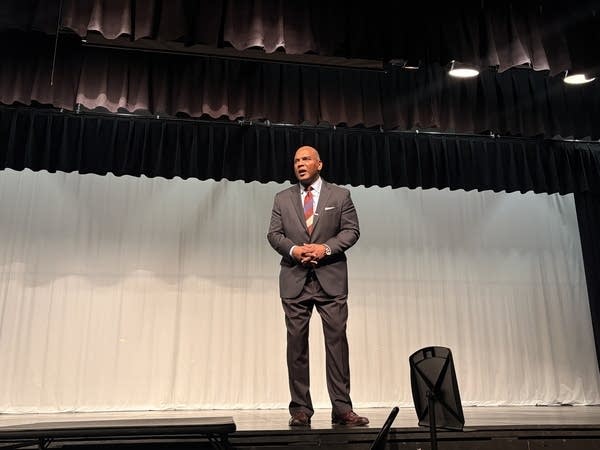 A man speaks from a stage