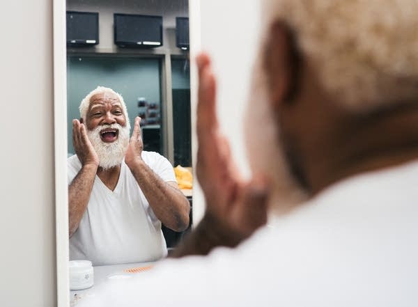 Santa Larry Jefferson shapes his beard .