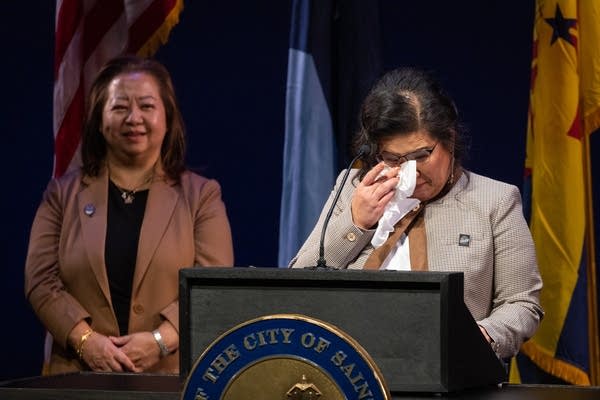 A woman wipes tears with a Kleenex