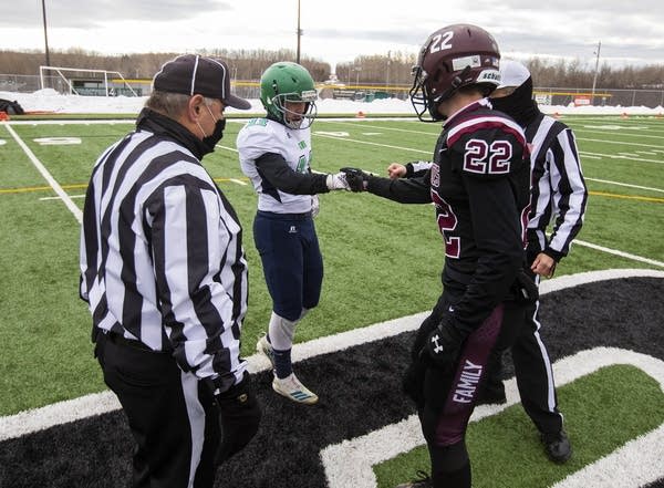 Two football players bump fists. 