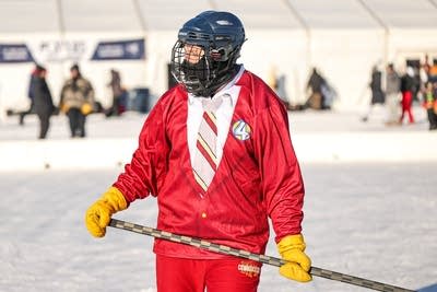 A hockey player wears a uniform resembling a red business suit.