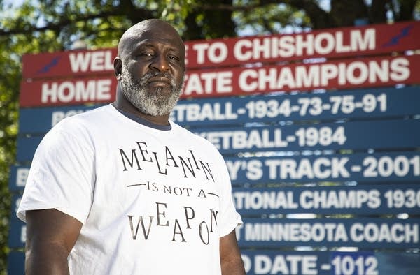 A man standing in front of a high school athletic championship sign. 