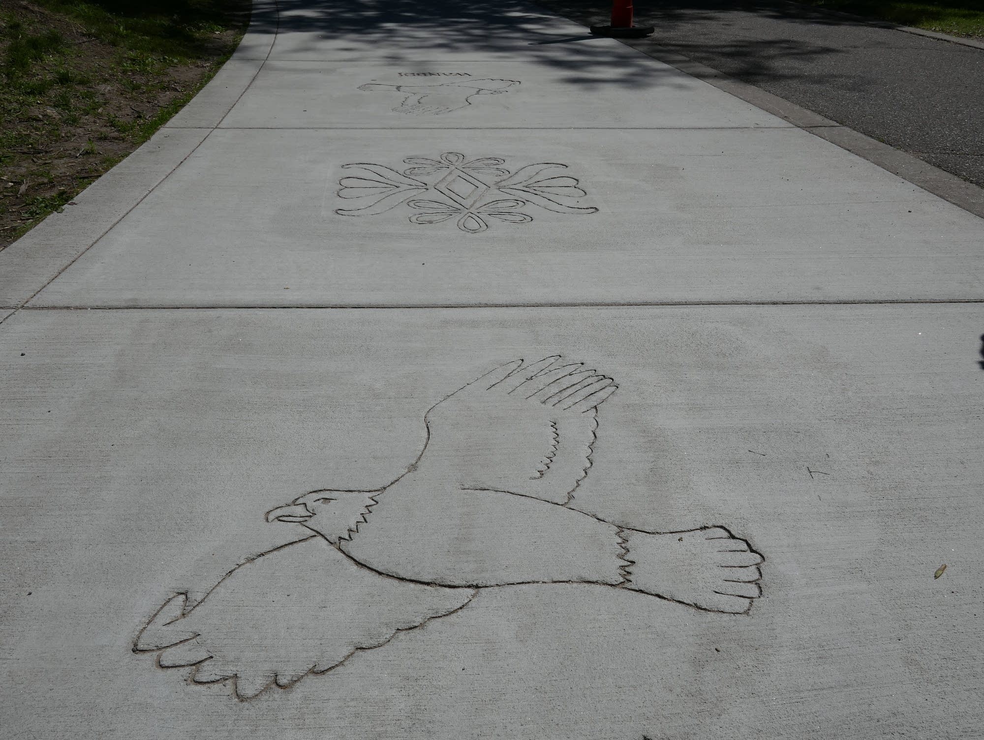 Sidewalk stamps of animals with their Dakota names