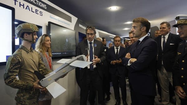 French President Emmanuel Macron, right, listens to the CEO of Thales Group, Patrice Caine, center, at the International Paris Air Show in June.