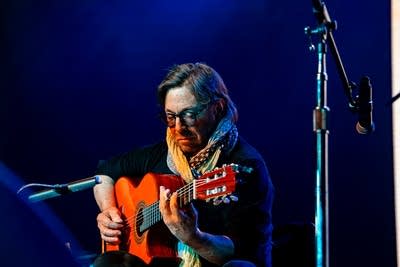 Al Di Meola performing with a guitar on stage