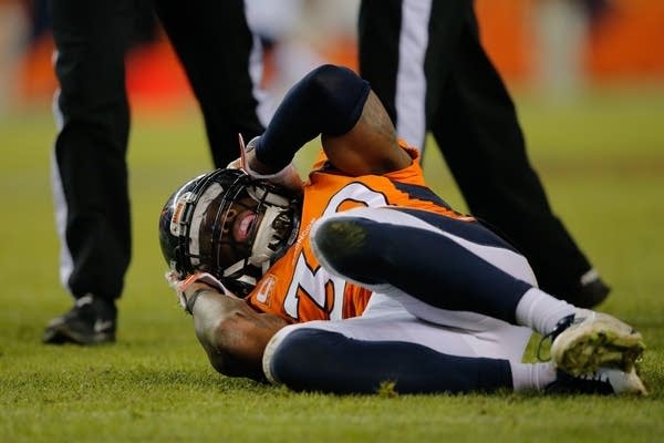 Denver Broncos player David Bruton lies on the gro