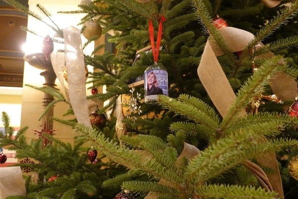A tree with an ornament with a picture of Melissa Hortman.