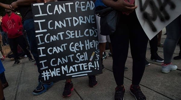 Protesters hold signs during a demonstration against police brutality in Charlotte, North Carolina, on September 21, 2016, following the shooting of Keith Lamont Scott the previous day.
