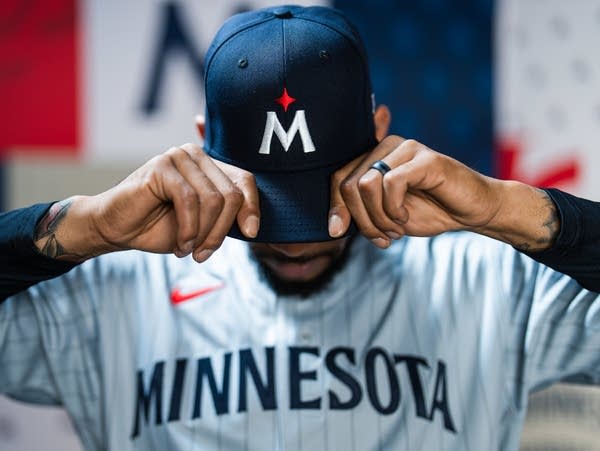 A Minnesota Twins baseball player shows off a new uniform