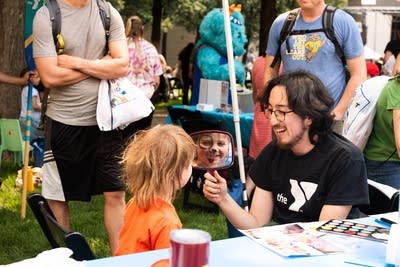 a kid with face paint looking in the mirror