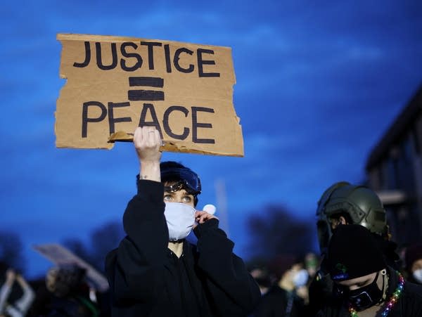 A demonstrator holds up a sign during a protest