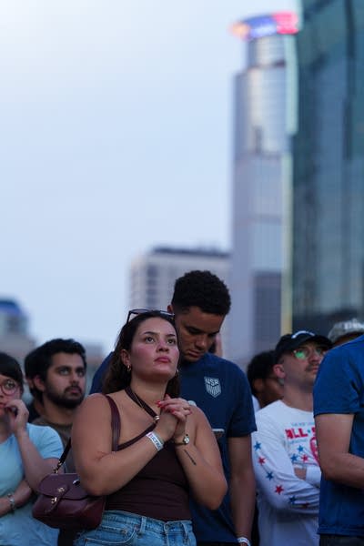 Two people watch a soccer game