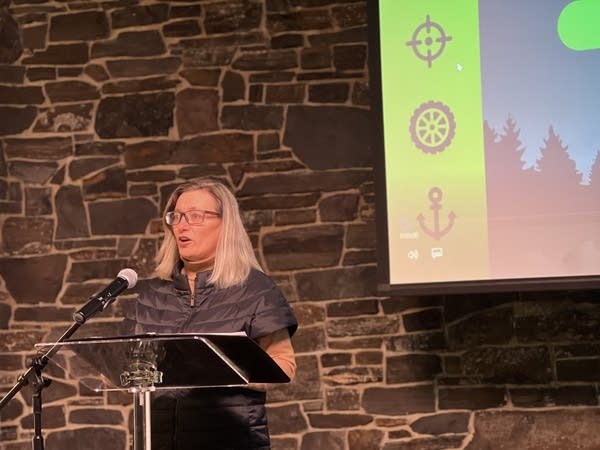 woman stands at podium