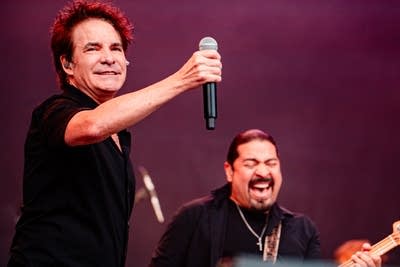 Two musicians performing together on a large outdoor stage