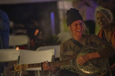 Woman laughing around campfire
